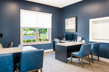 Office with blue chairs and a desk and a window